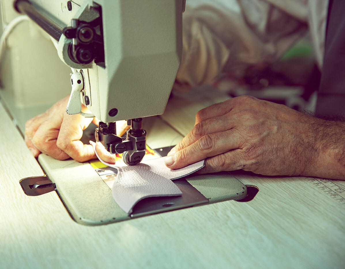 man sewing leather